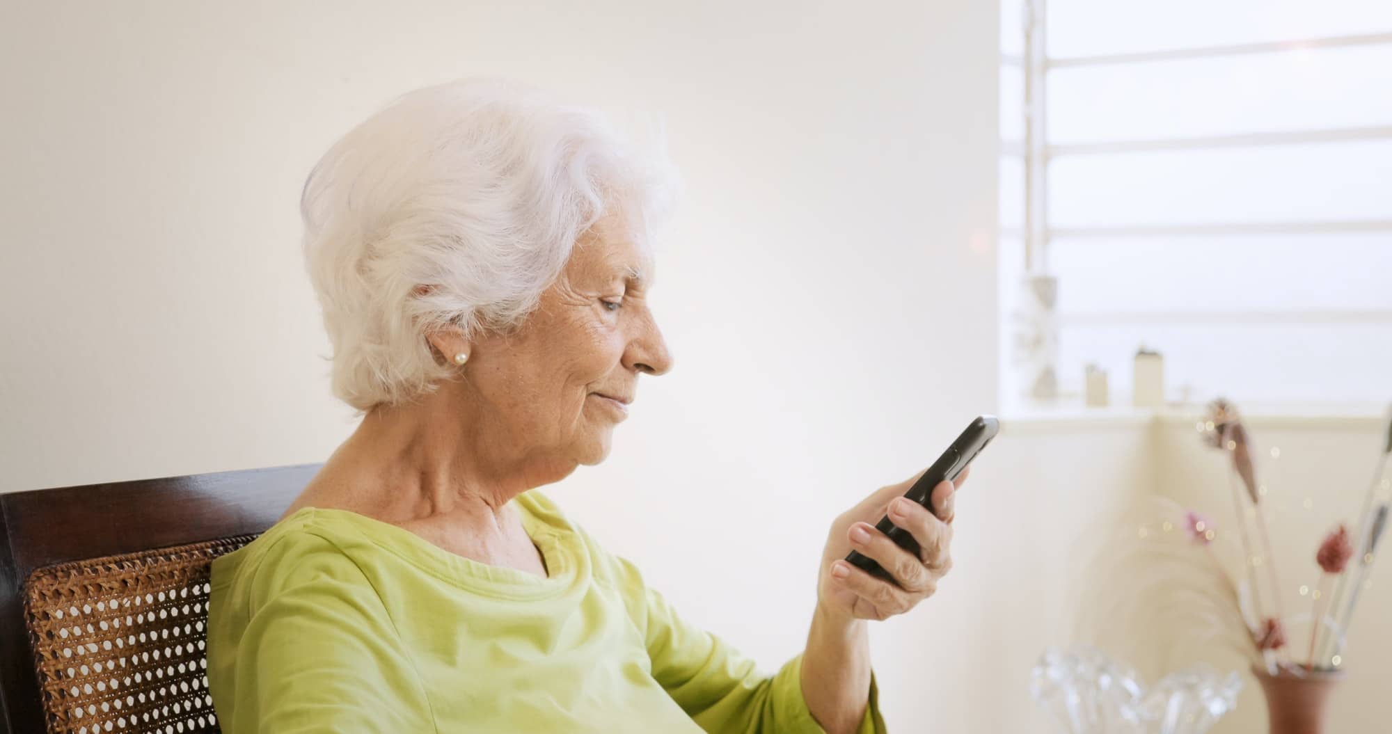 Happy Old Woman Using Mobile Phone For Leisure